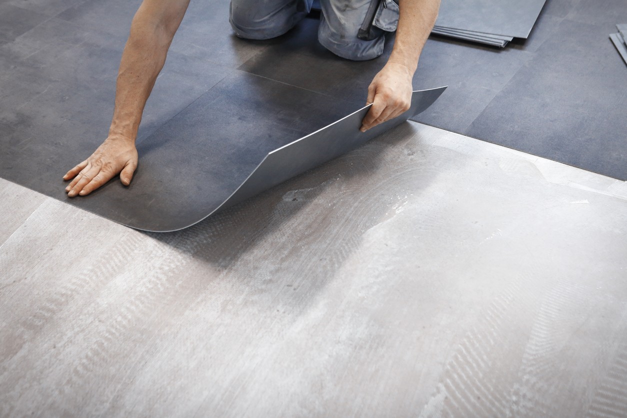 Worker making flooring with vinyl tiles